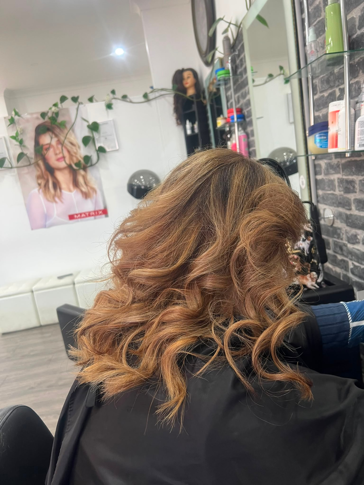 Warm copper shoulder length curls viewed from the side