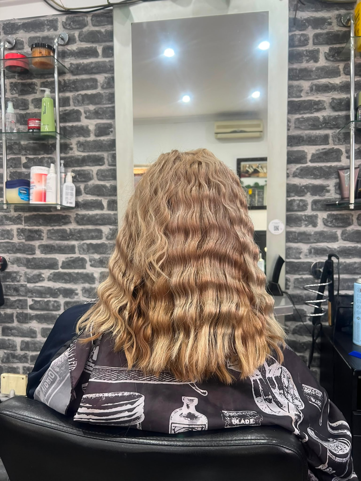 Shoulder length blonde hair styled with soft textured waves
